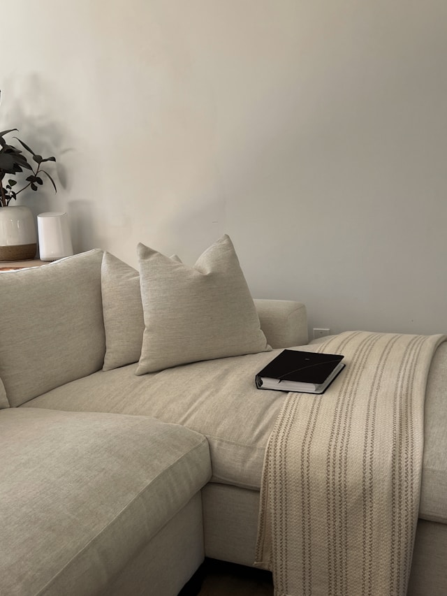 Open laptop on a neutral sofa showing a casual work-from-home setup