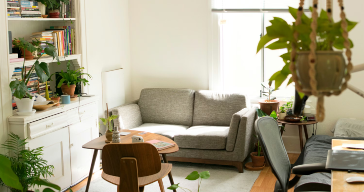 Small apartment living room with compact gray sofa, tiny dining table and desk in one bright space