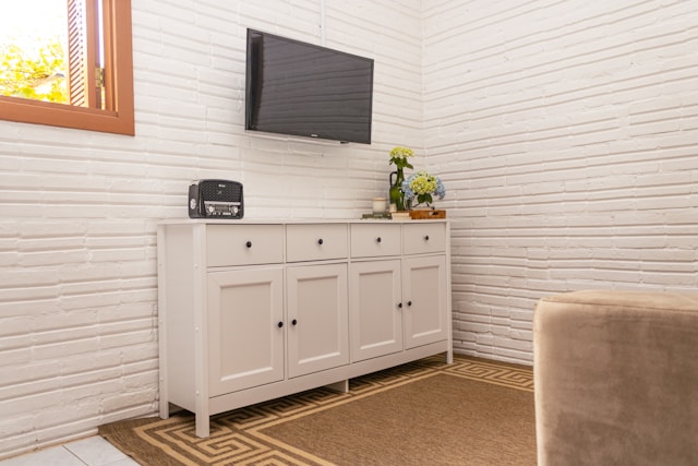 White sideboard with a television mounted above