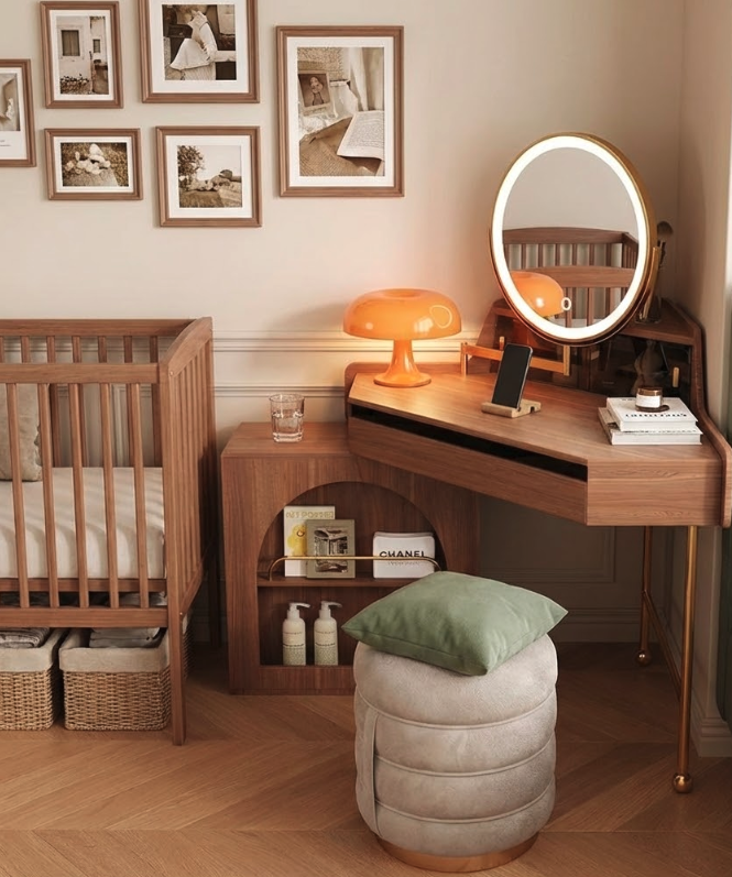 Warm wooden corner makeup vanity with round illuminated LED mirror, open shelves for books and skincare, orange lamp, cushioned stool, and nearby crib – versatile mid-century option in makeup vanity buying guide.