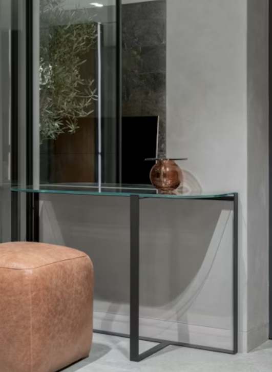 a glass console table with a vase on top of it