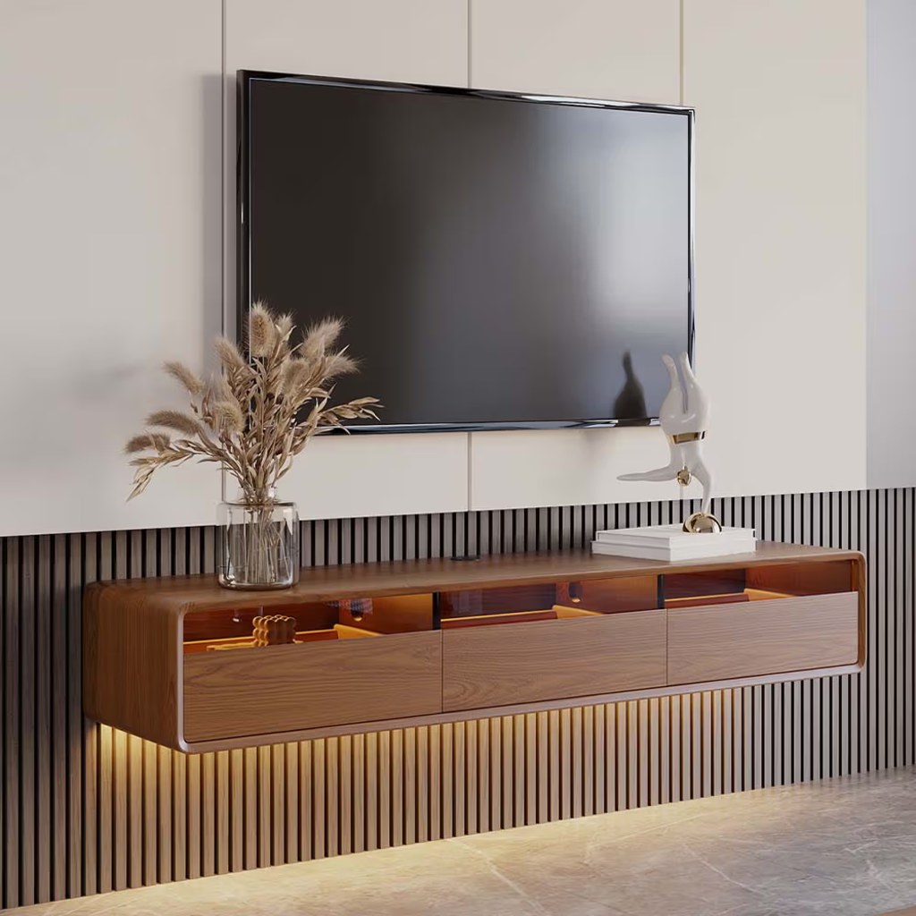 Wall-mounted walnut TV console with drawers, open storage, warm LED lighting, and a flat-screen TV above.