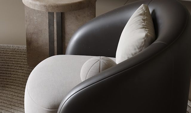 modern accent chair with neutral pillow next to a small side table in a minimalist living room