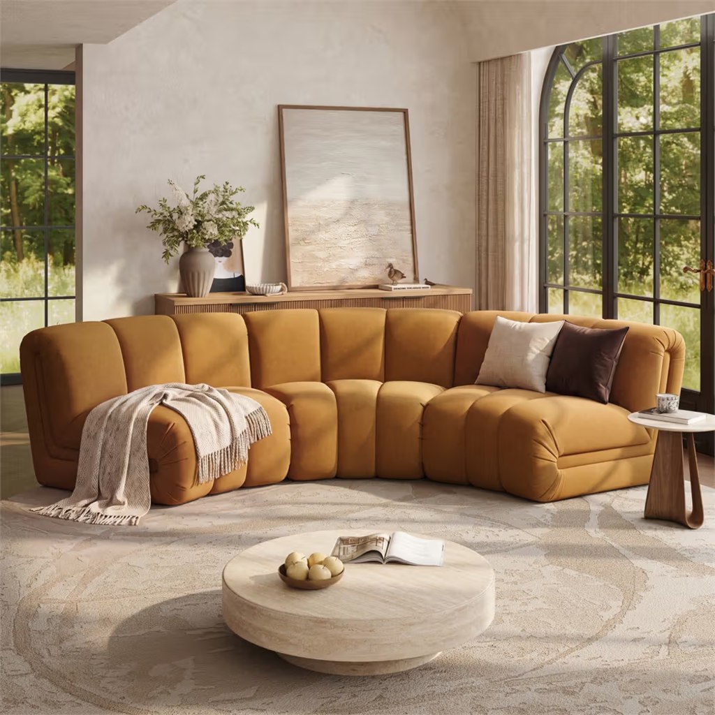 Mustard yellow curved modular sectional sofa with plush channel cushions in a bright modern living room.