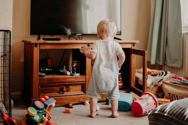A Toddler Playing near TV stand