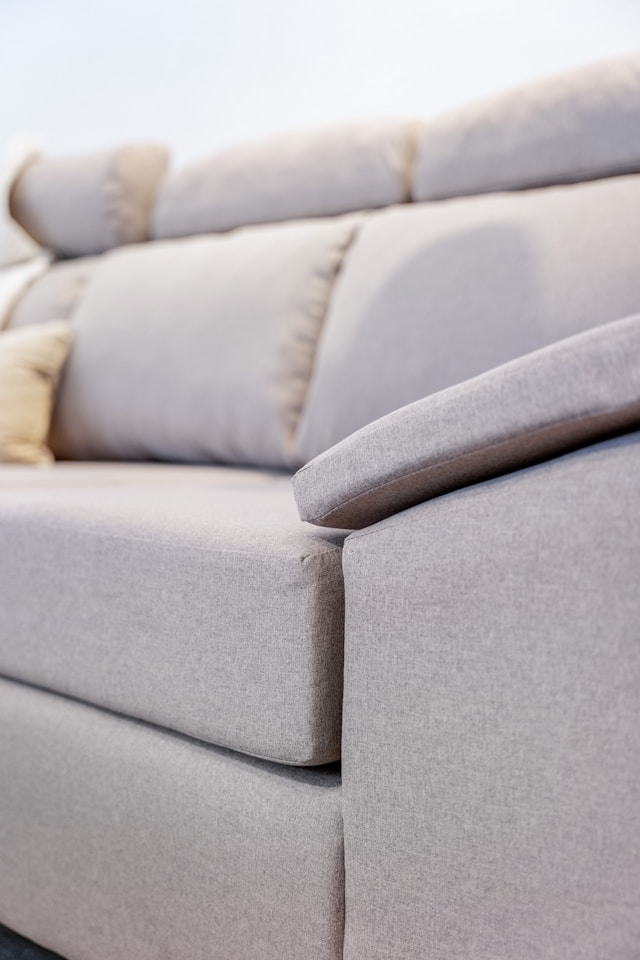 A close-up of a light grey fabric sofa