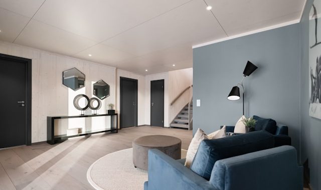 A living room with a blue couch and a round coffee table