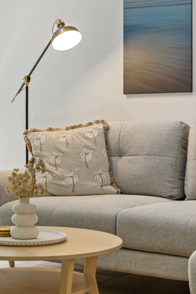 A living room with a couch, coffee table and lamp