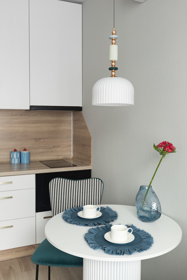 A small dining table with two cups and a flower