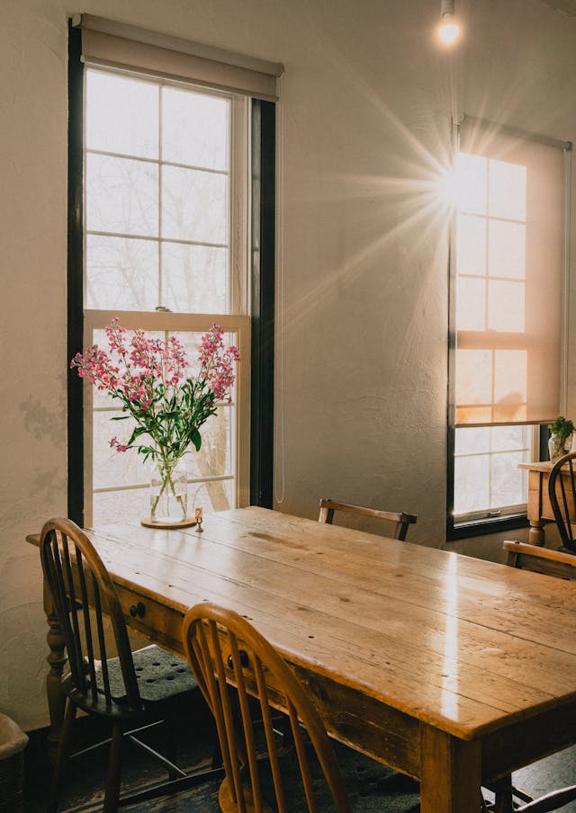 Cozy sunlit dining room with wooden table