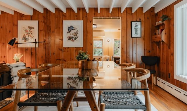 Mixed-material dining space with wood paneling and glass table