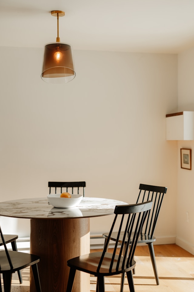 Modern sunlit dining area with wooden table and chairs