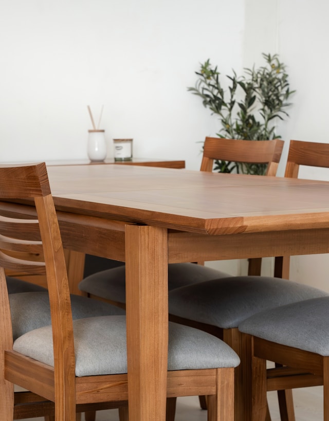 Wooden dining table with grey upholstered chairs