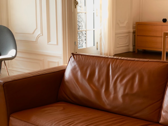 a brown leather couch sitting in a living room