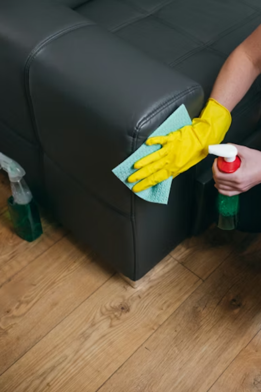 a person cleaning a black couch