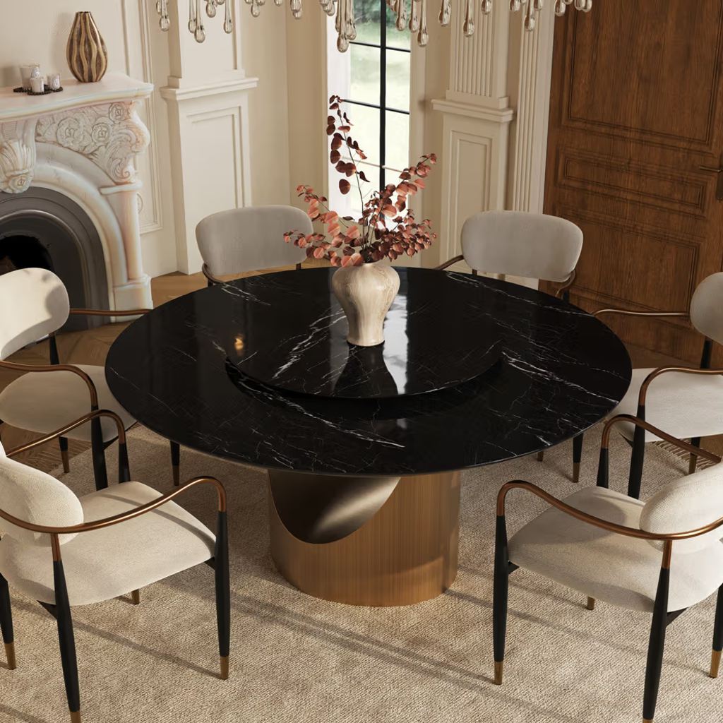 Black round marble dining table with a central Lazy Susan and cream upholstered chairs in an elegant dining room.