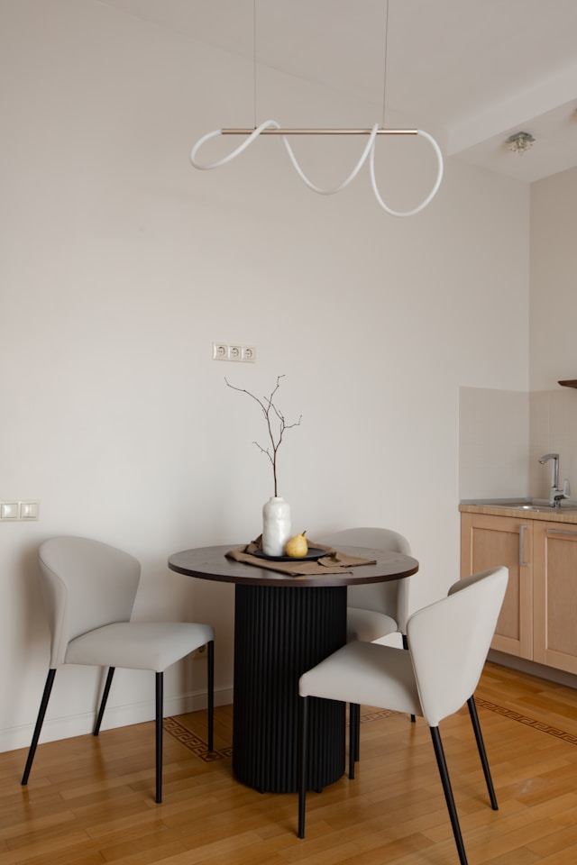 modern dining area with a round wooden dining table and four chairs in a bright kitchen