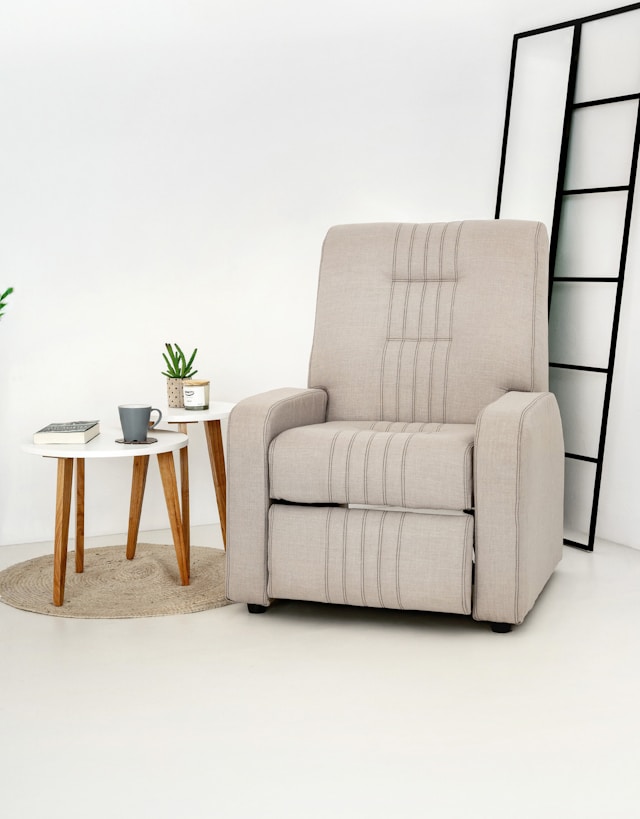 A beige recliner chair with a small side table