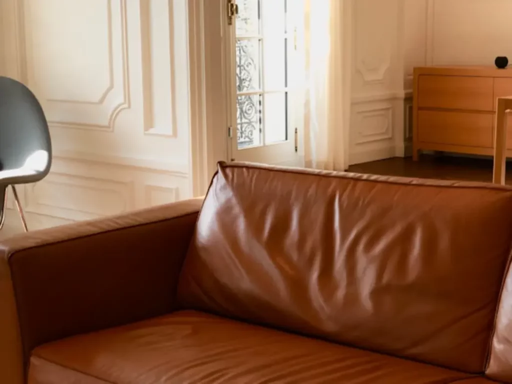 a brown leather couch sitting in a living room