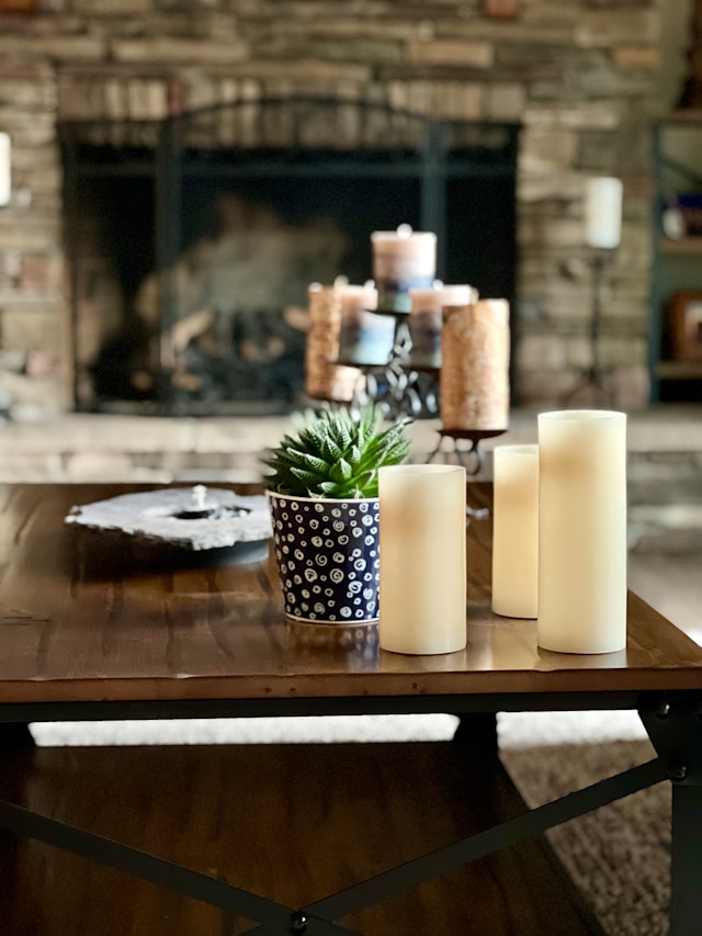 a coffee table decorated with candles and a plant