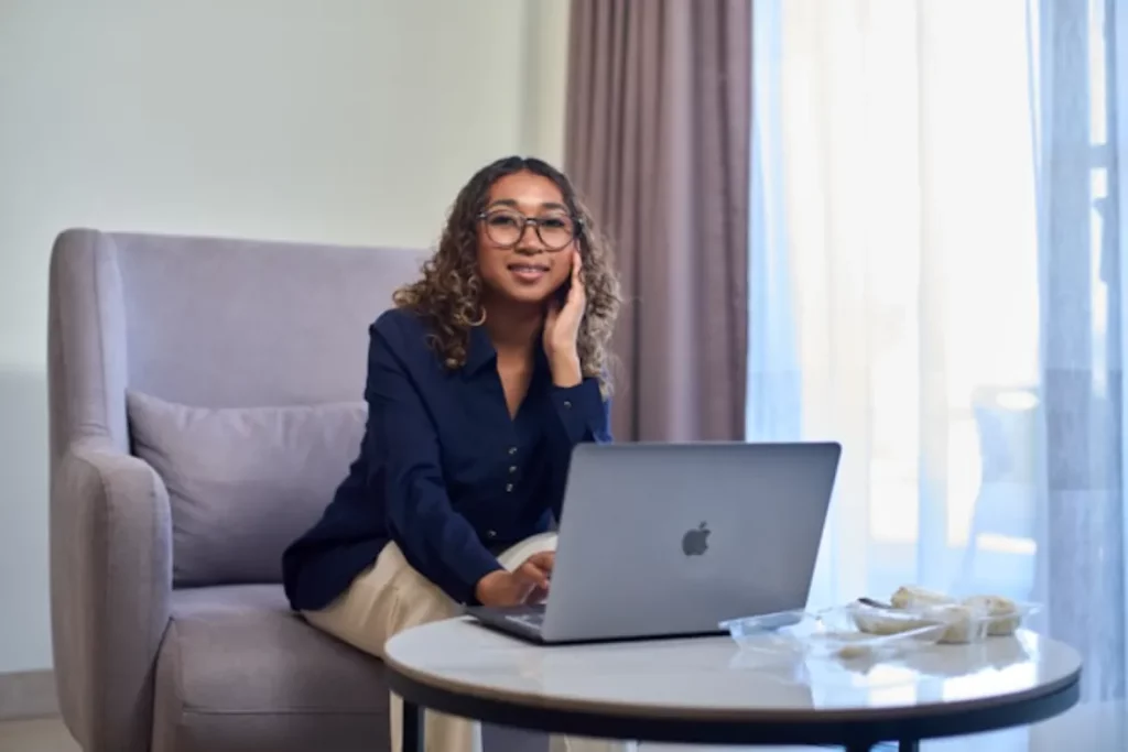 a women sitting on a couch working on laptop