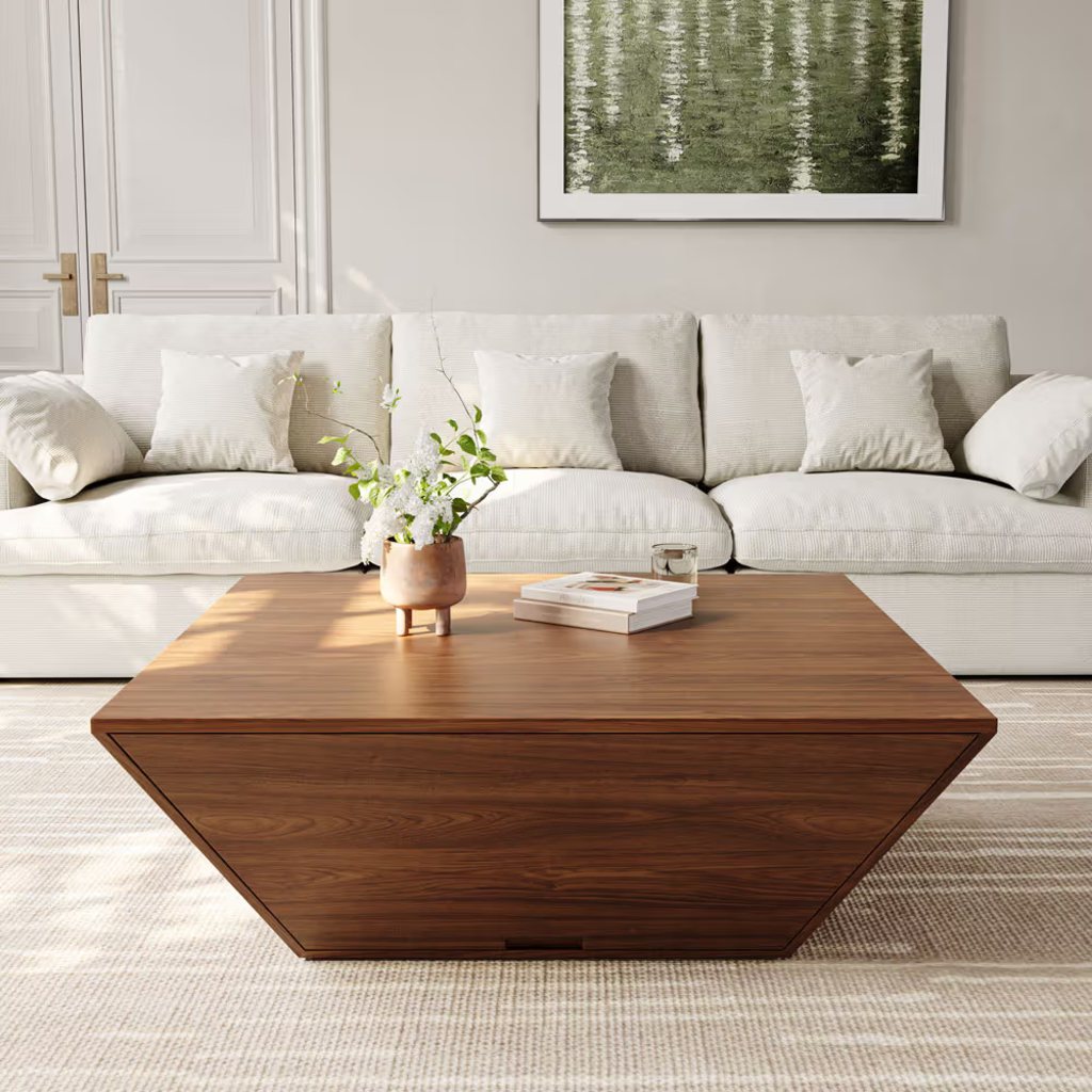 Square walnut coffee table with a low geometric base in front of a cream sofa in a bright modern living room.