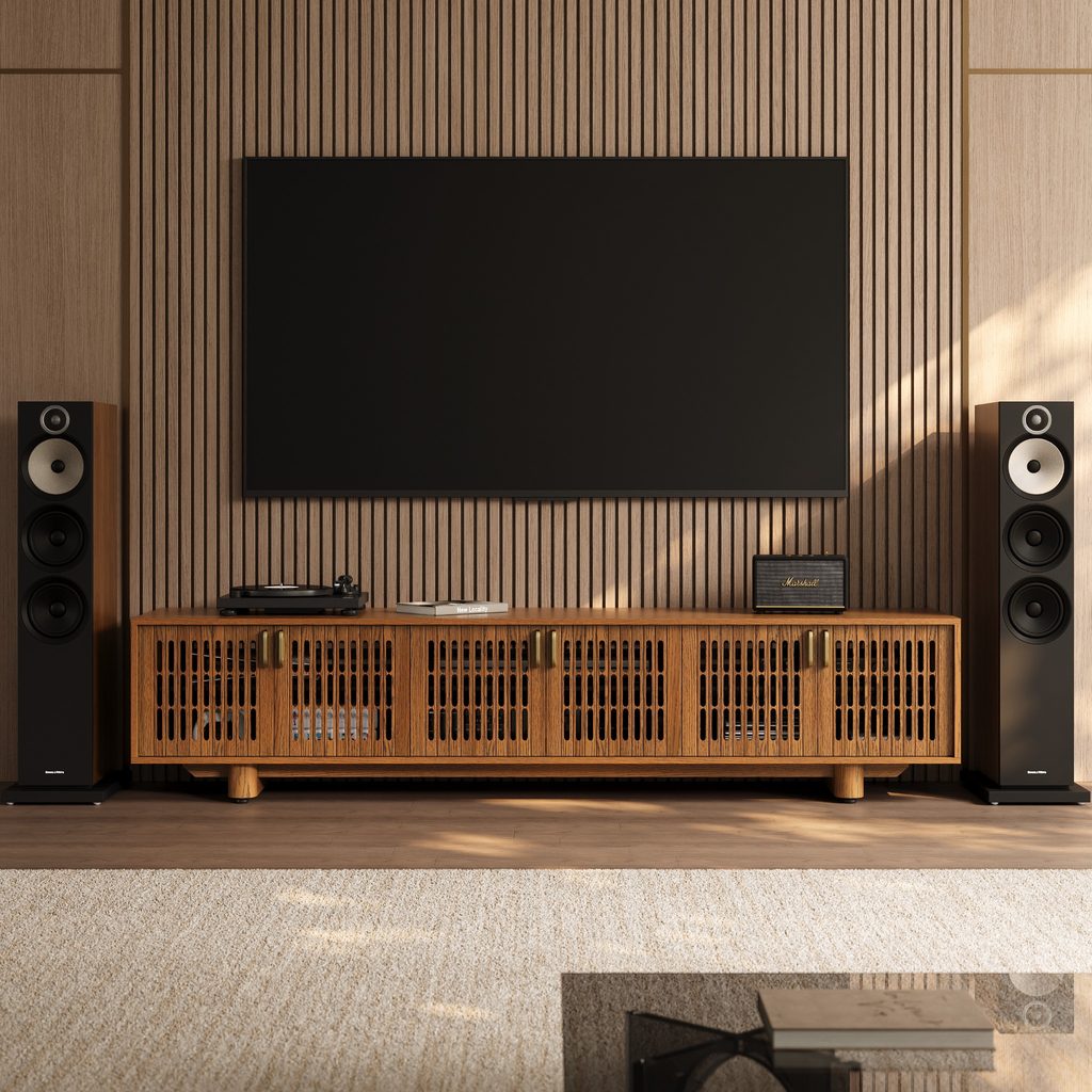 Walnut media console with ventilated slatted doors, turntable, speakers, and audio equipment beneath a wall-mounted TV in a modern living room.