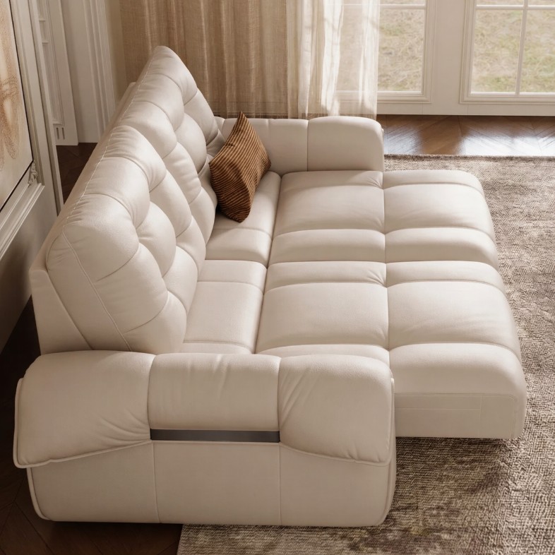 a cream colour leather power sofa bed with a cushion in a bright living room