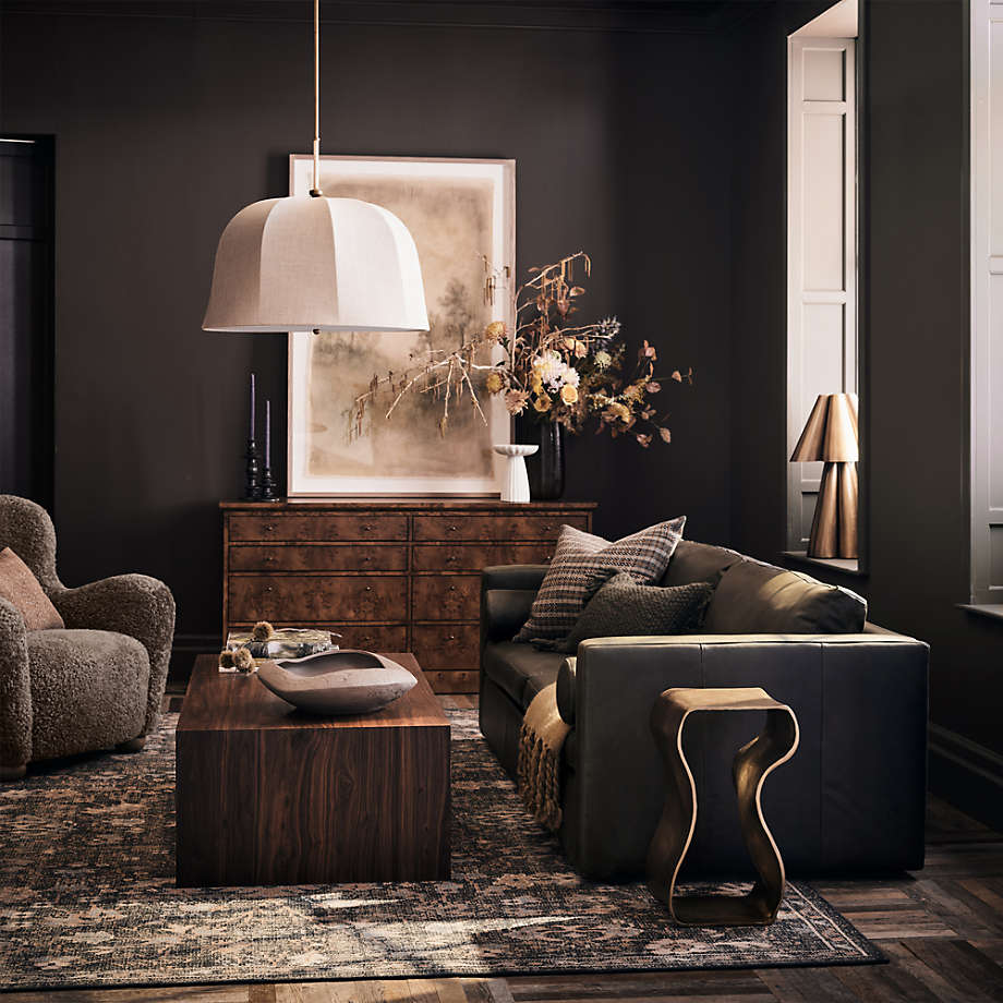 a black leather sleeper sofa with cushions for overnight guests in a small living room