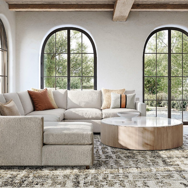 Reversible Storage Chaise Lounge Queen Sleeper Sectional Sofa near a round glass coffee table in a modern living room