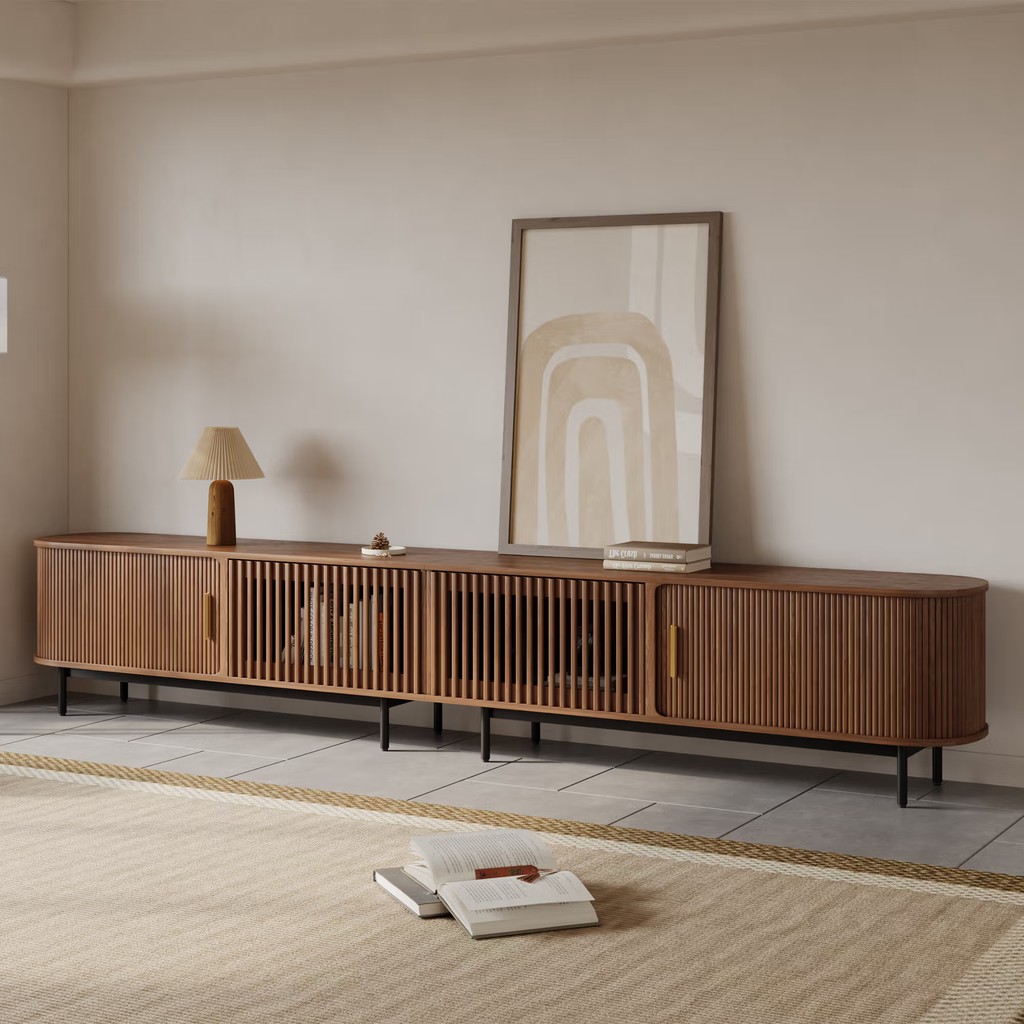 Long walnut media console with slatted cabinet doors and open center storage in a minimalist neutral living room.