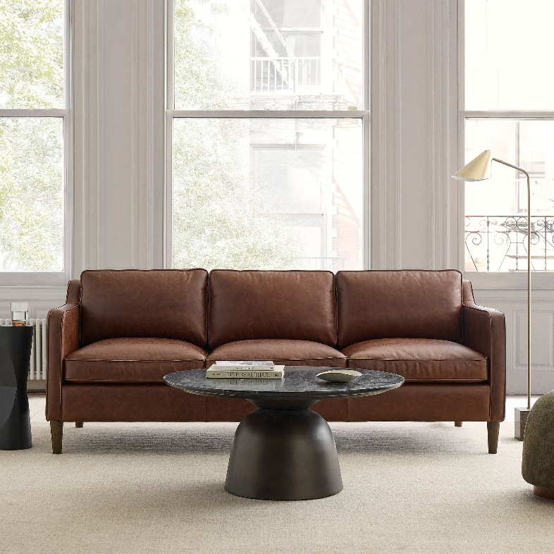 West Elm Hamilton brown Leather Sofa near a coffee table in a bright and cozy living room