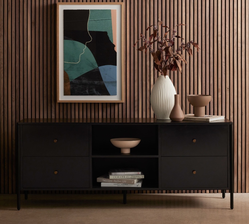 a black tv stand with storage and decorations against a wall