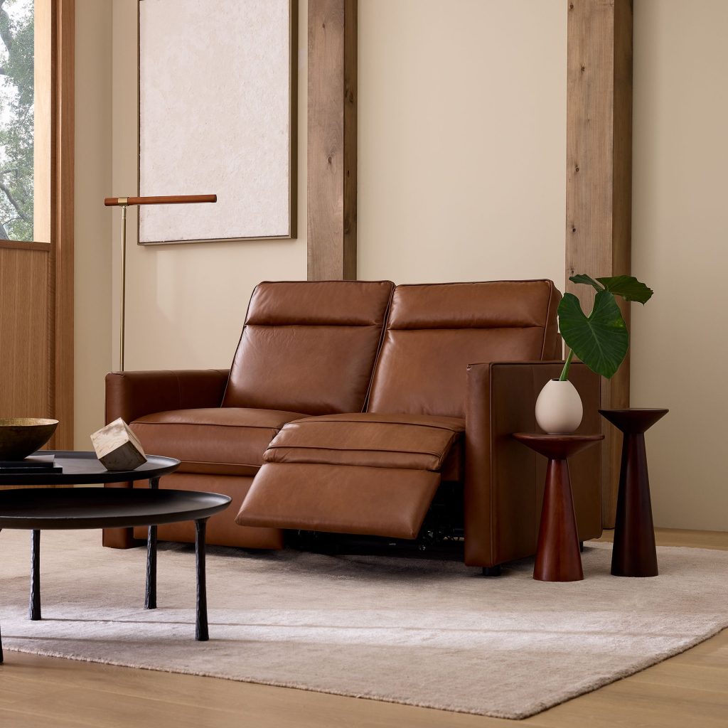 a brown leather reclining sofa near a   coffee table in the living room