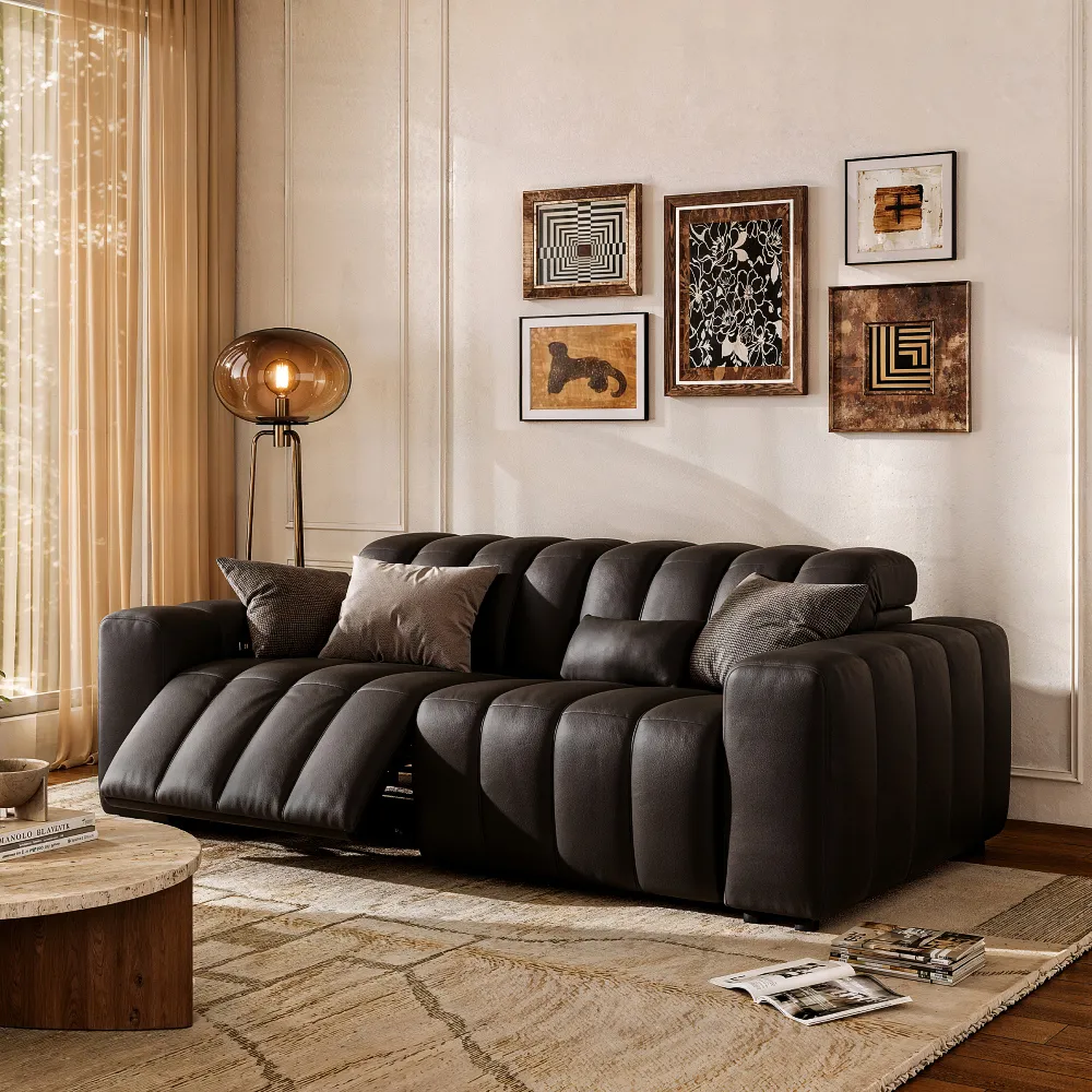 Black leather dual power reclining loveseat with channel-tufted cushions and one extended footrest in a warm living room.