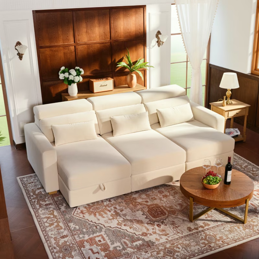 Cream modular power sofa bed with three extended seats and adjustable headrests in a warm wood-paneled living room.