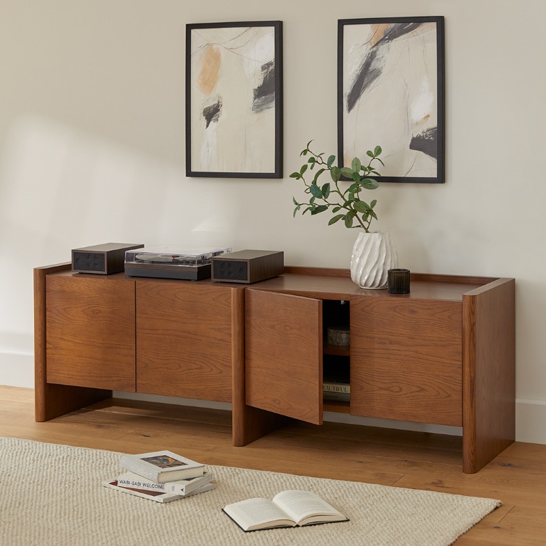 a tv stand with storage and drawers, a disc player, a plant and other decorations on top