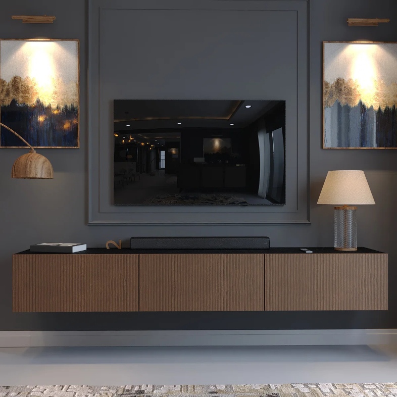 a wall-mounted floating media console with a book and a lamp on top and a tv above near two paintings in a modern living room