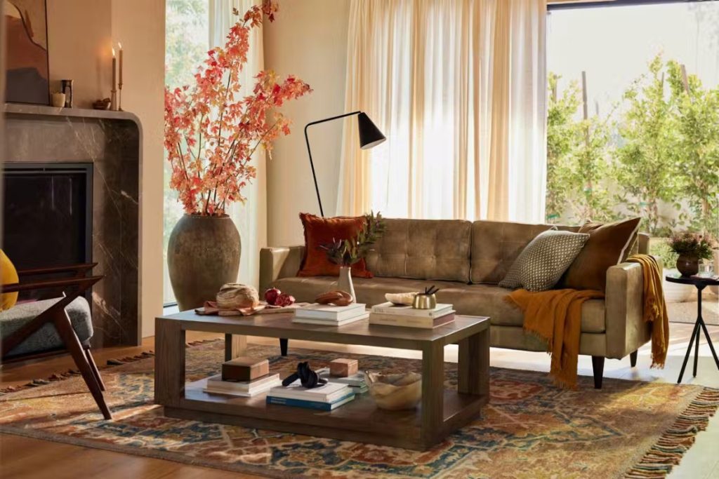 a cream colour-like leather sofa with cushions near a wood coffee table in a bright living room