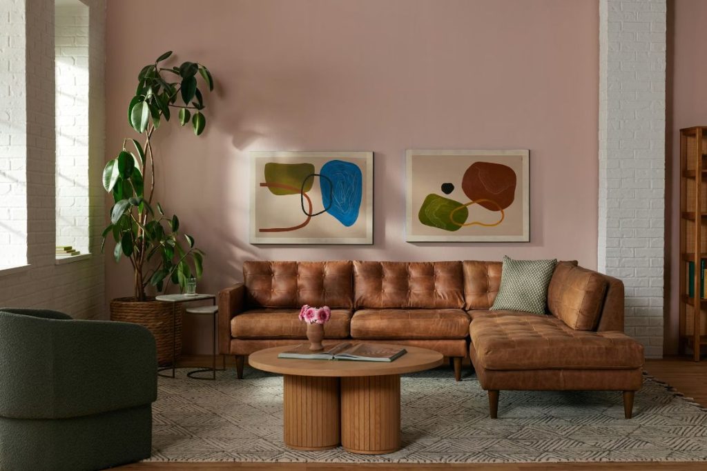 Brown leather chaise sectional sofa in a modern living room with tufted cushions and mid-century style
