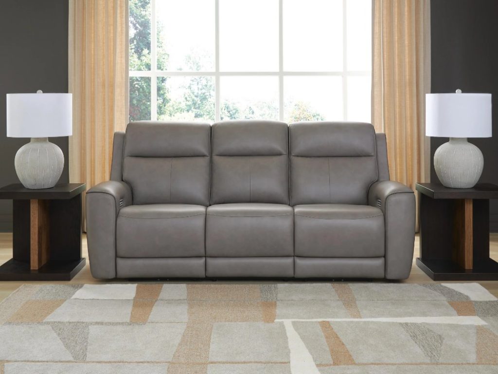 Dual Power Leather Reclining Sofa between two side tables in a modern and cozy living room
