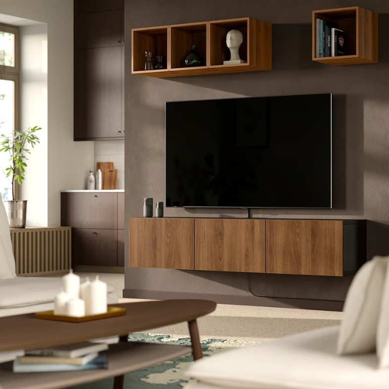 a walnut media console with a tv on top near sofas and a oval coffee table in a modern and cozy living room