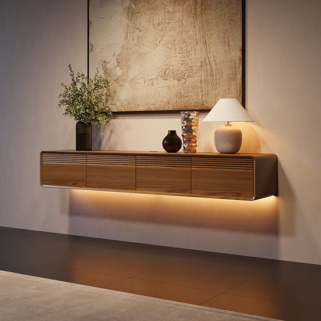 Wall-mounted walnut floating TV console with four drawers, warm LED lighting, and decorative accents in a modern living room.
