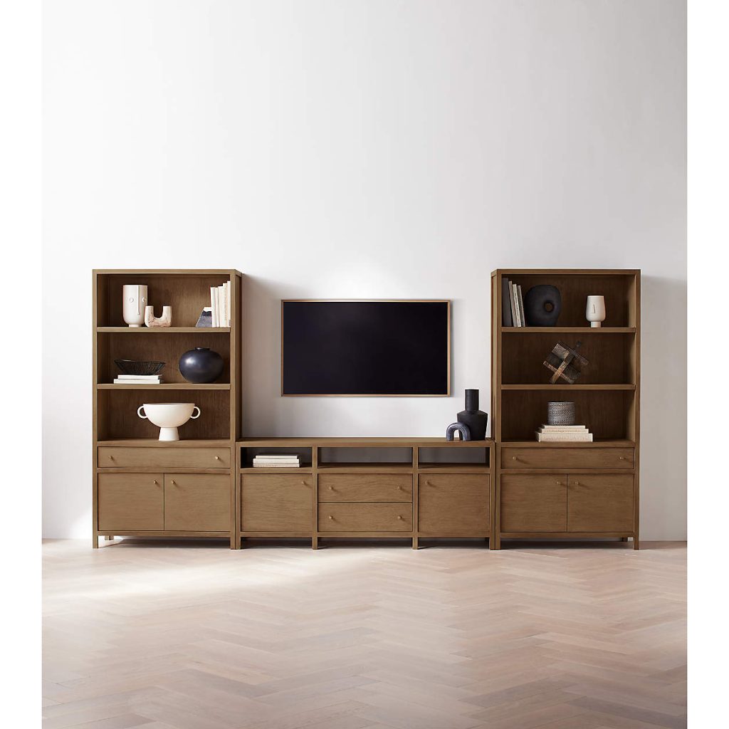 Crate & Barrel Keane 86" Driftwood Storage Media Console with drawers for books and decoration on top, a mounted tv above between shelves in a minimalist and mid-century living room
