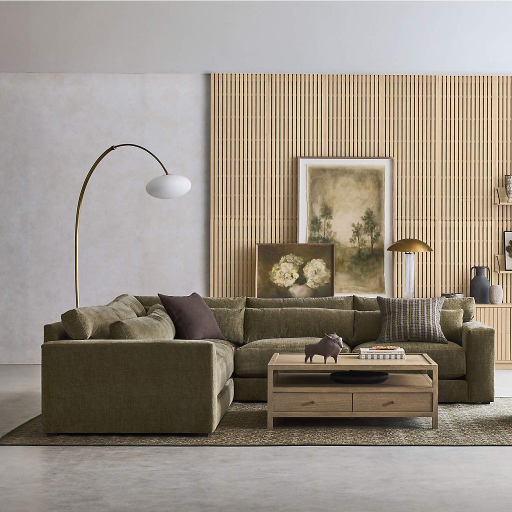 Crate & Barrel Retreat Sectional in L shape with roll cushions and square arms near a rectangular wood coffee table and a floor lamp in a modern living room