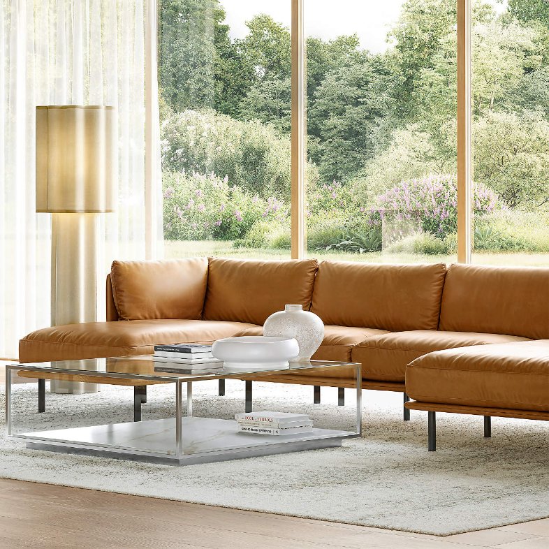 Crate & Barrel Wells 84" Leather Sofa with chaise near a rectangular glass coffee table with some books and decorations in a bright and modern living room against a giant window
