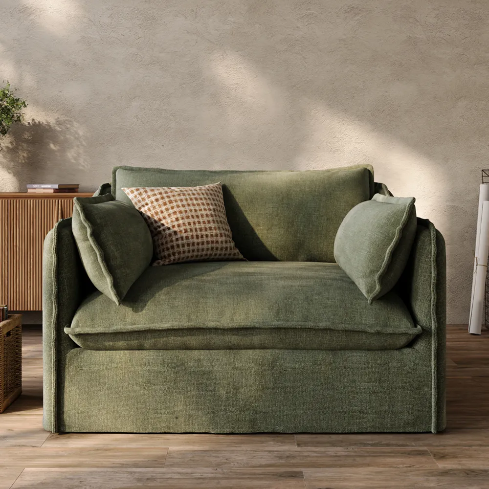 A soft green upholstered sofa with deep seats, removable covers, and a relaxed modern shape for family living rooms.