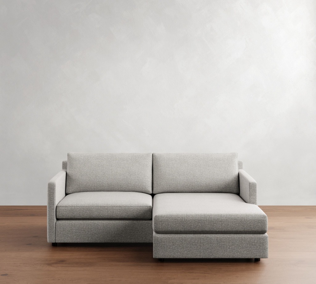 Light gray chaise sectional sofa on a wood floor against a simple white wall.