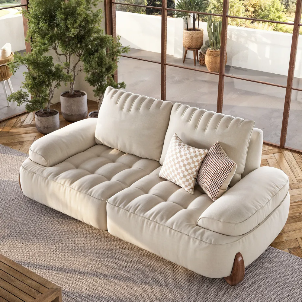 Cream fabric sofa in a bright living room, showing a surface where rubber gloves and upholstery vacuuming can remove daily cat hair.