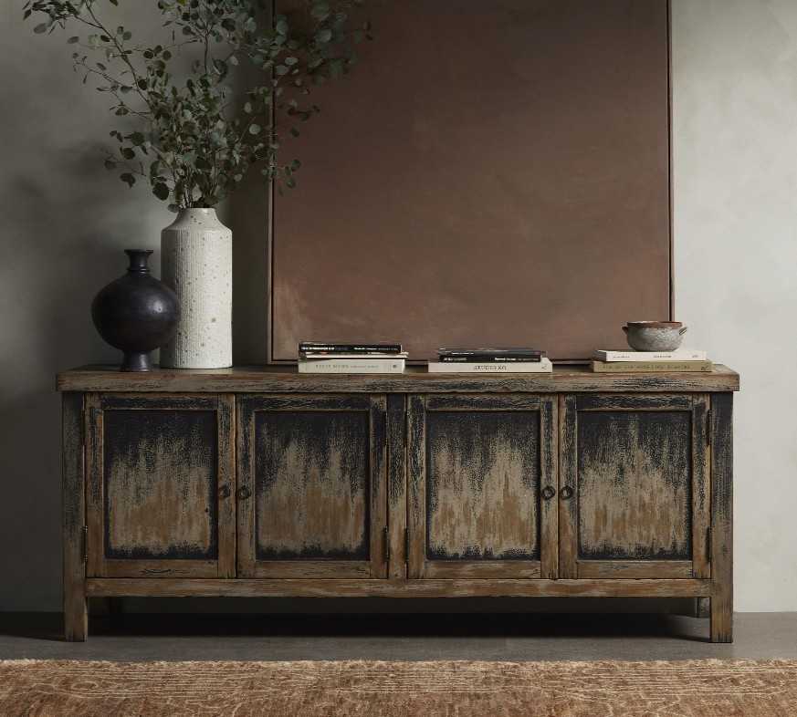 Pottery Barn Feller Media Console in a rustic style with drawers and books, plants and a painting on top in a mid-century living room